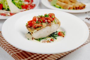 side-view-baked-seabass-with-tomatoes_141793-2616