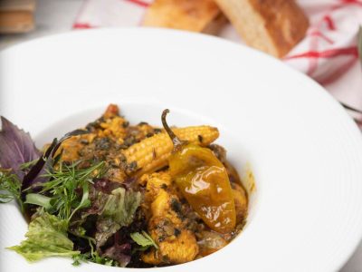 vegetable-stew-with-meat-corn-pieces-chili-pepper-vegetables-basilic-parsley-white-plate_114579-208